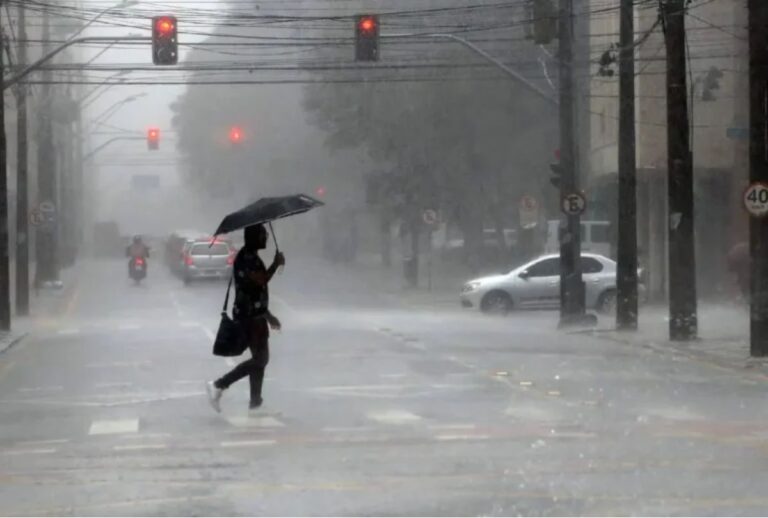 Pessoa atravessando a rua com guarda-chuva