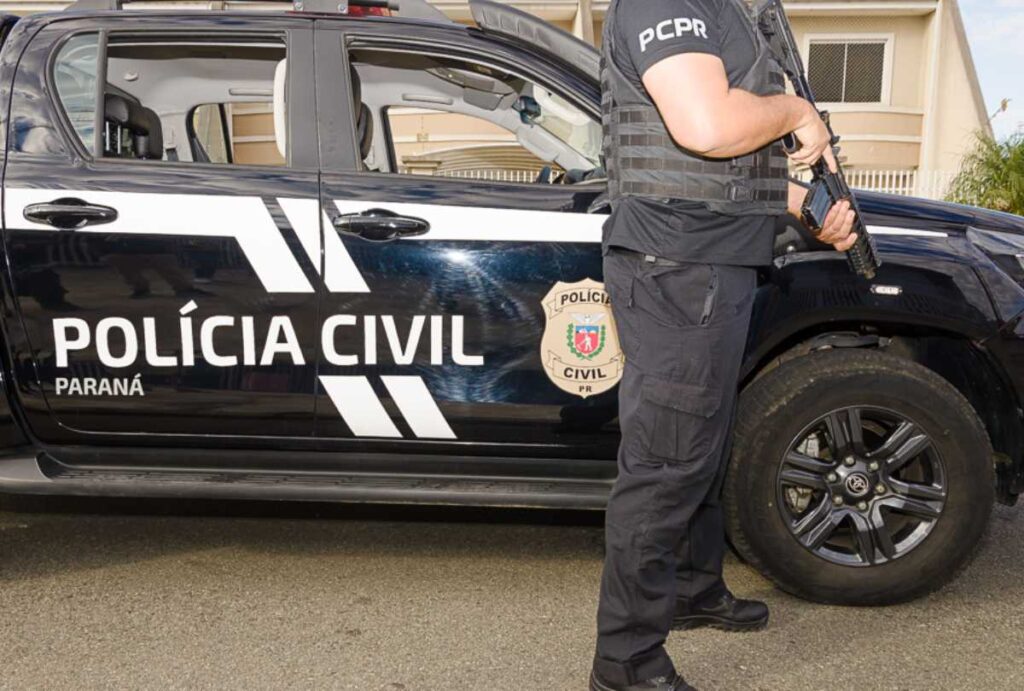 Policial ao lado de uma viatura da Polícia Civil do Paraná