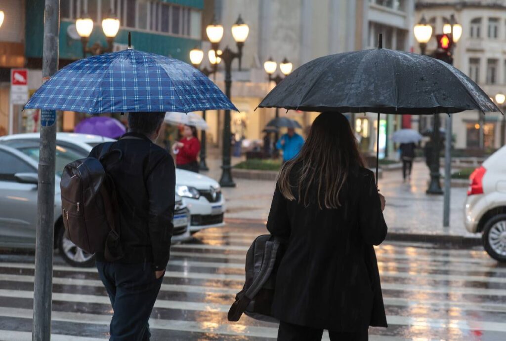 Pessoas andando com guarda-chuva em Curitiba