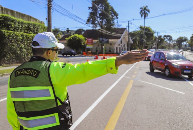 Guarda de trânsito sinalizando rua.