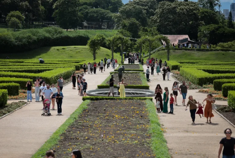 Pessoas caminhando em parque em dia de sol