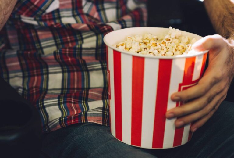Homem segurando balde de pipoca