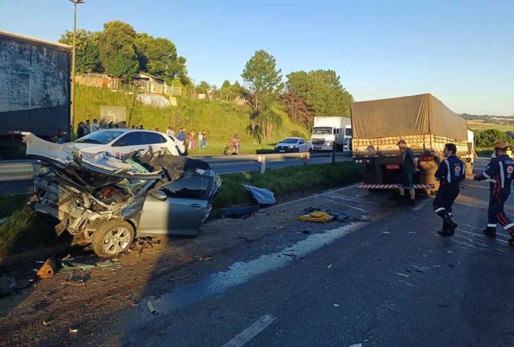 Carro destruído entre carretas na BR-376