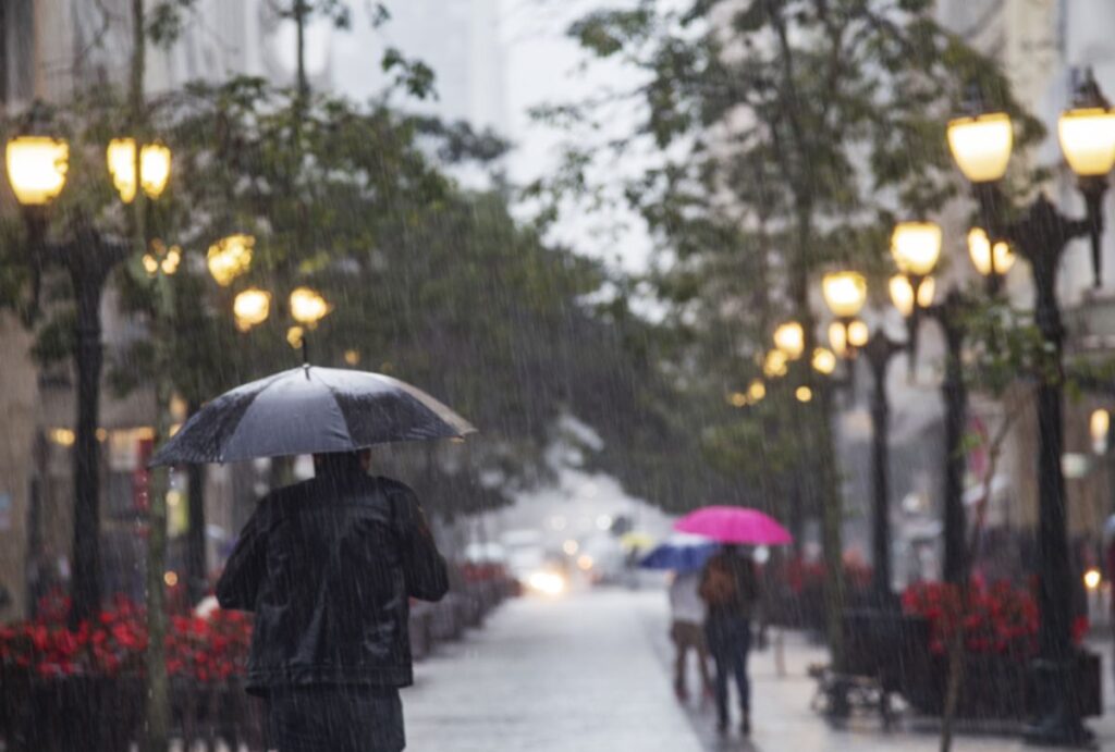 Pessoas com guarda-chuva andando em Curitiba