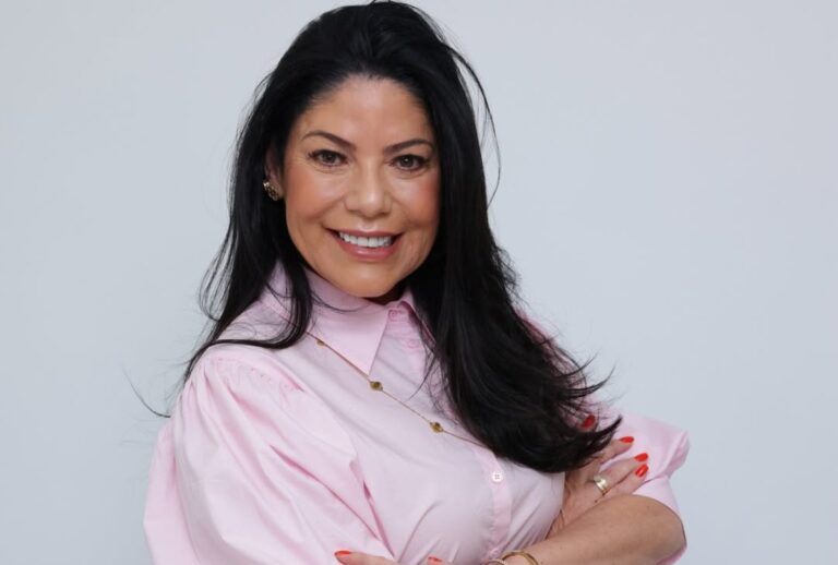 Beth Guzzo sorrindo com uma camisa cor de rosa