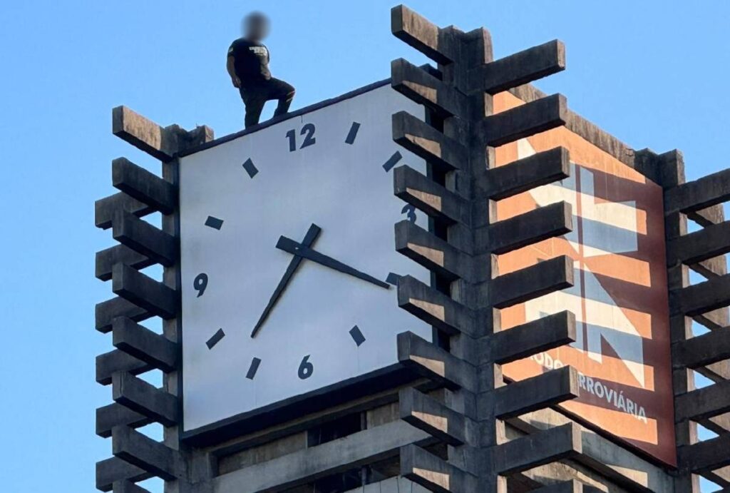 Homem no topo do relógio na Rodoviária de Curitiba