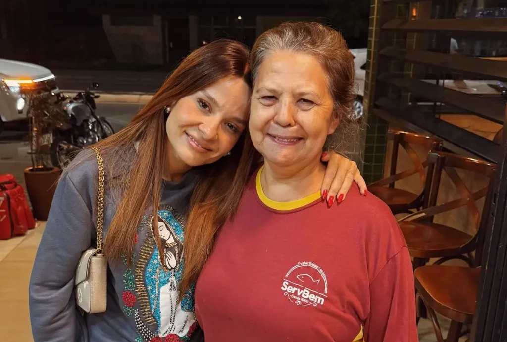 Maiara ao lado de funcionária de pizzaria