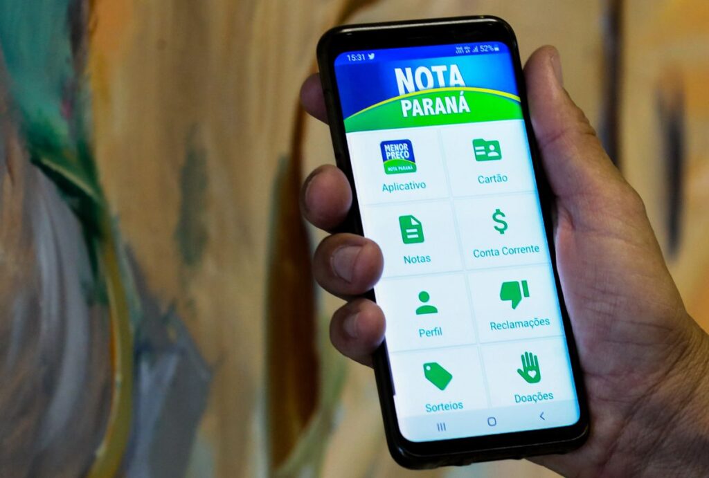 Pessoa segurando o celular com o app do Nota Paraná