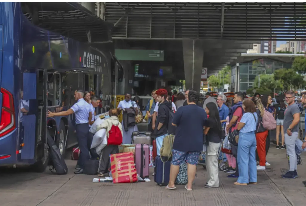 rodoviaria de curitiba cheia de pessoas embarcando em ônibus