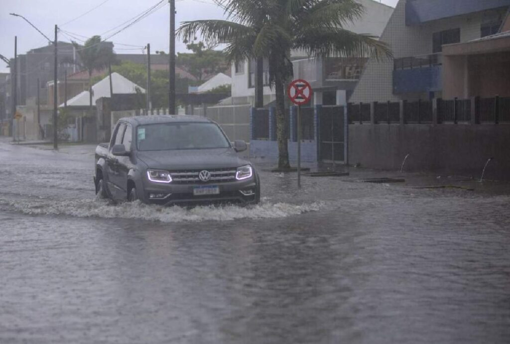 Carro passando por rua alagada