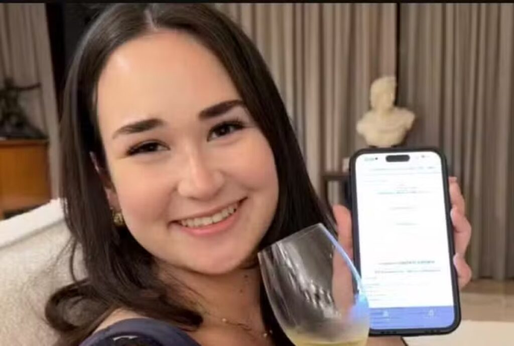 Mariana Tanaka Abdul Hak com um celular nas mãos