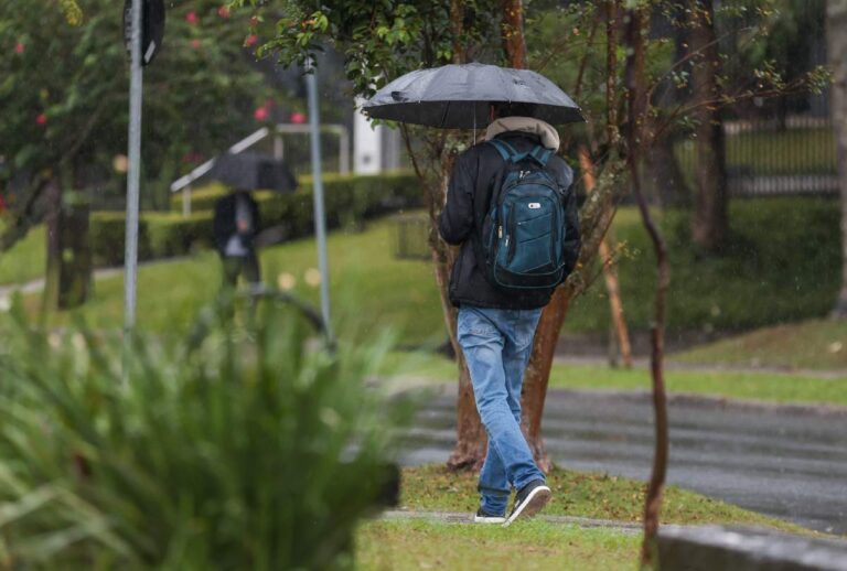 Homem andando com guarda-chuva