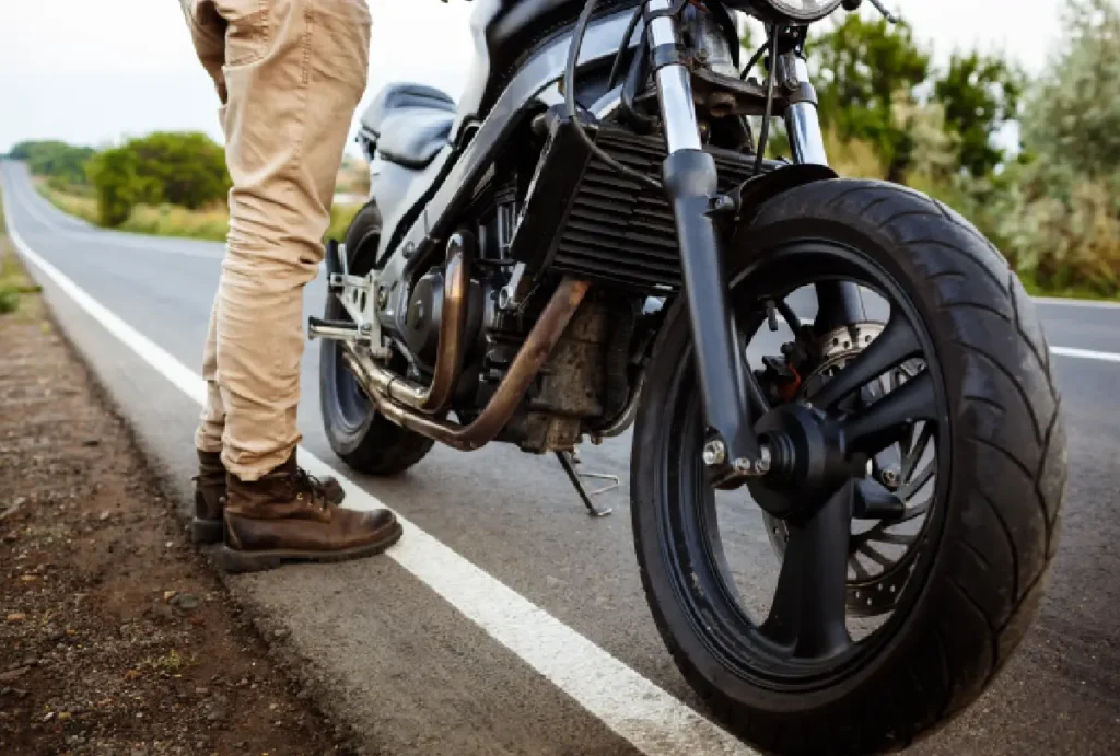 Homem parado ao lado de moto