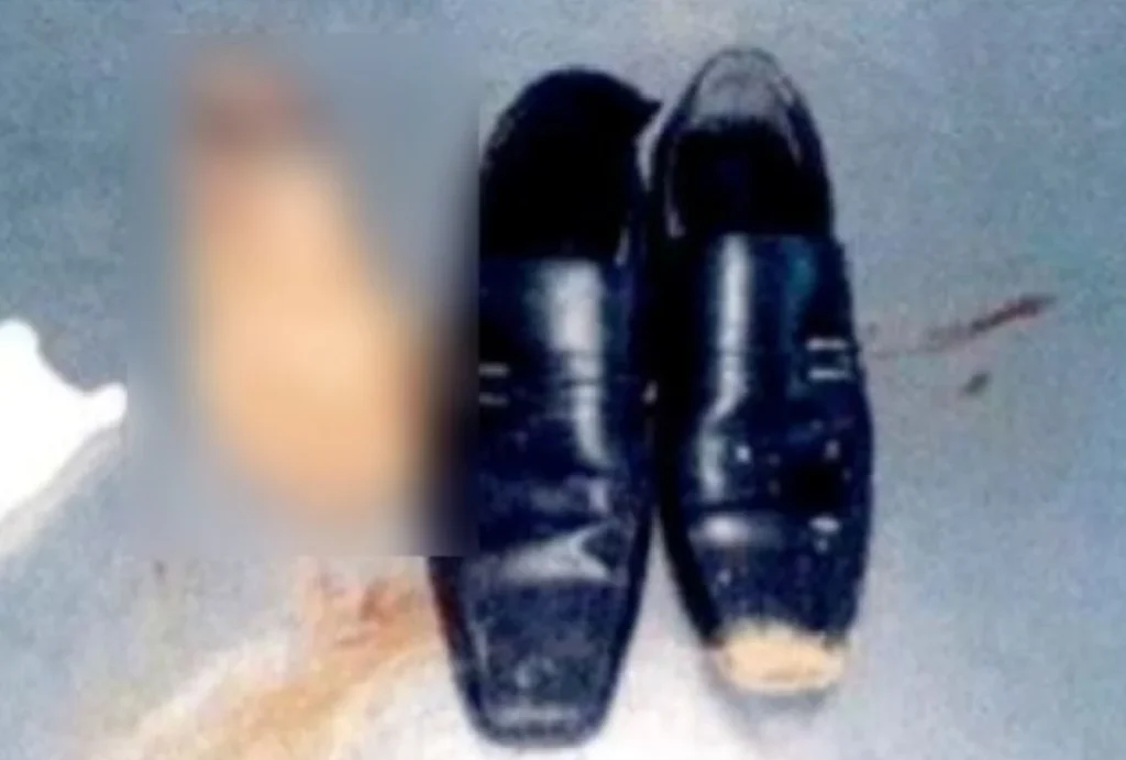 Foto do pé amputado censurado do homem, ao lado do sapato desgastado dele.